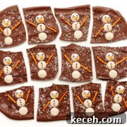 Snowman Christmas chocolate bark cut into pieces on a white background.