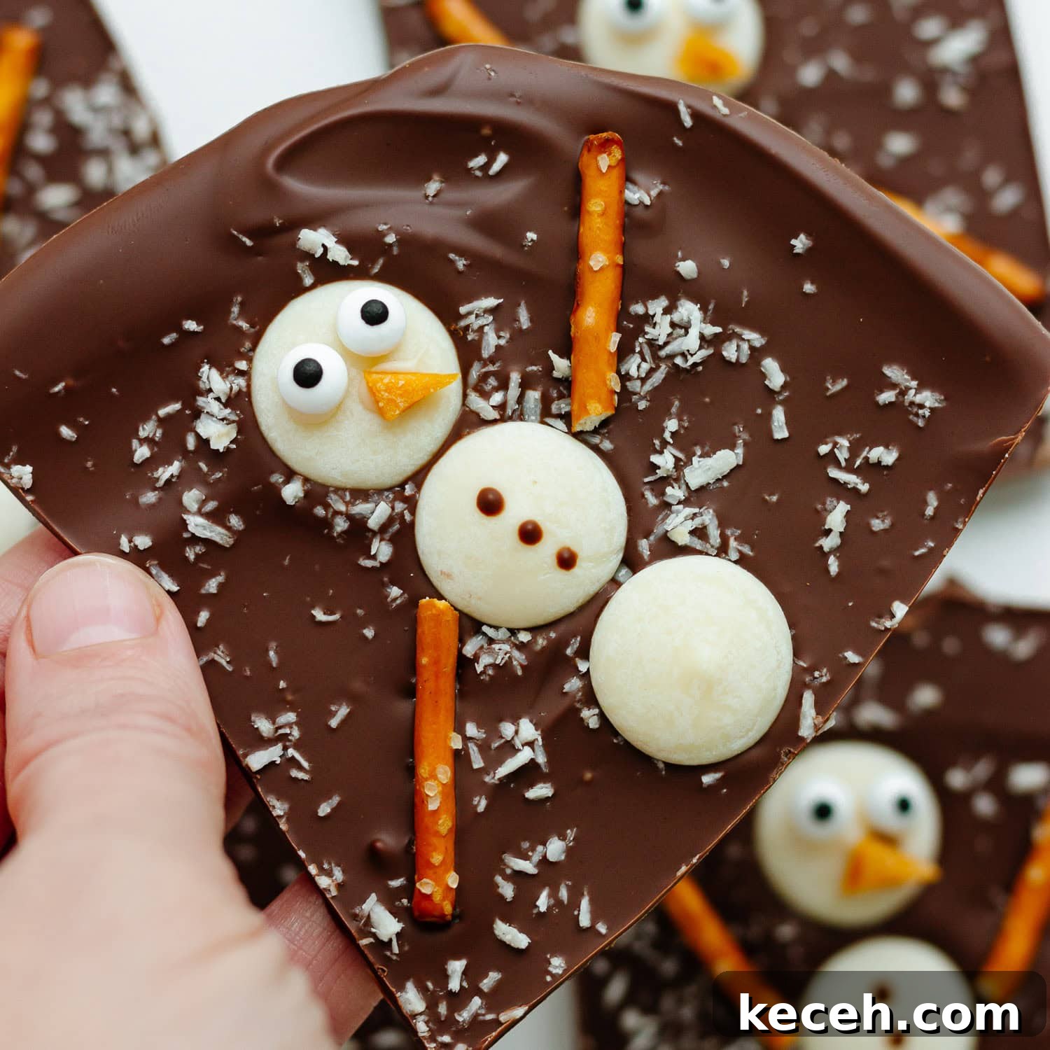 Snowman Chocolate Bark Recipe for Christmas Treats 3 Hand holding a piece of snowman bark.