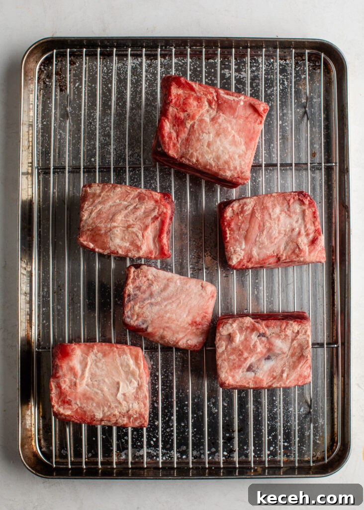 Red Wine Braised Beef Short Ribs with Rich Sauce 5 seasoned short ribs on a pan with with wire rack