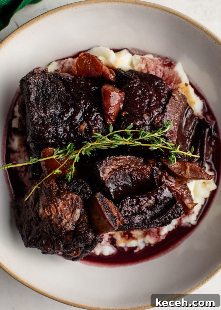 Red Wine Braised Beef Short Ribs with Rich Sauce 8 braised beef short ribs over a bed of mashed potatoes topped with a sprig of fresh thyme.