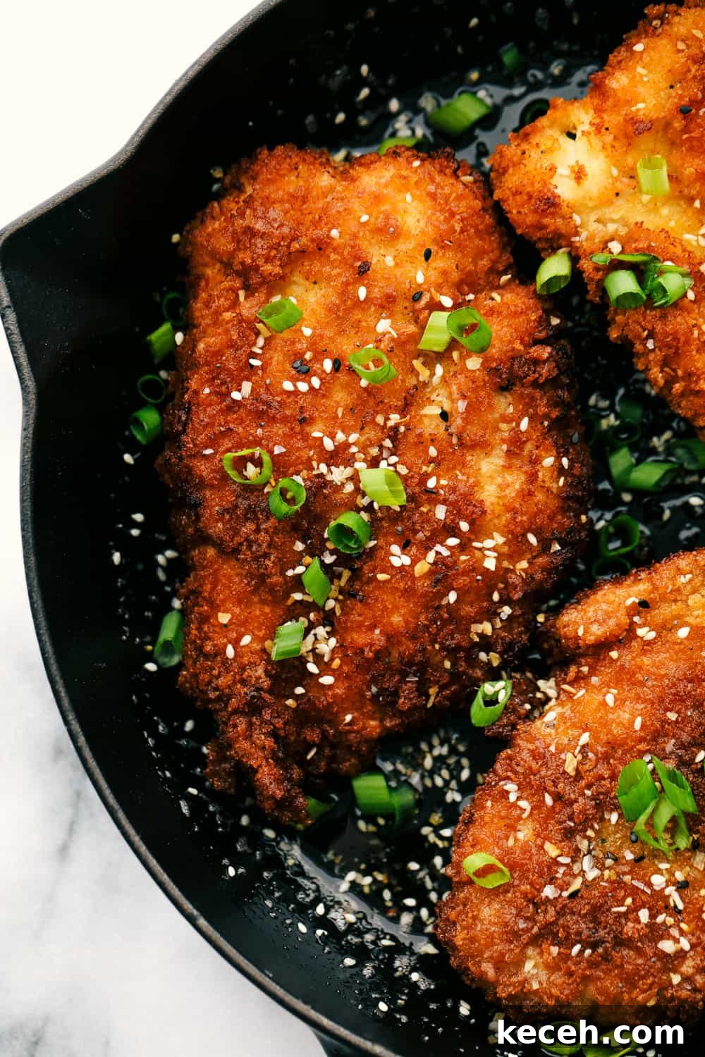 Awesome Chicken Katsu is a crispy breaded chicken breast seasoned and dipped in Panko then lightly fried in oil until the crust becomes a golden brown. A light and savory Japanese dish! Chicken Katsu fired golden brown.