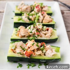 Four Lobster Cucumber Boats on a white serving platter topped with chives