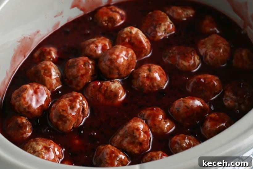 Slow-Cooker Grape Jelly BBQ Meatballs Recipe 5 Close up of slow cooker filled with grape jelly meatballs and barbecue sauce.