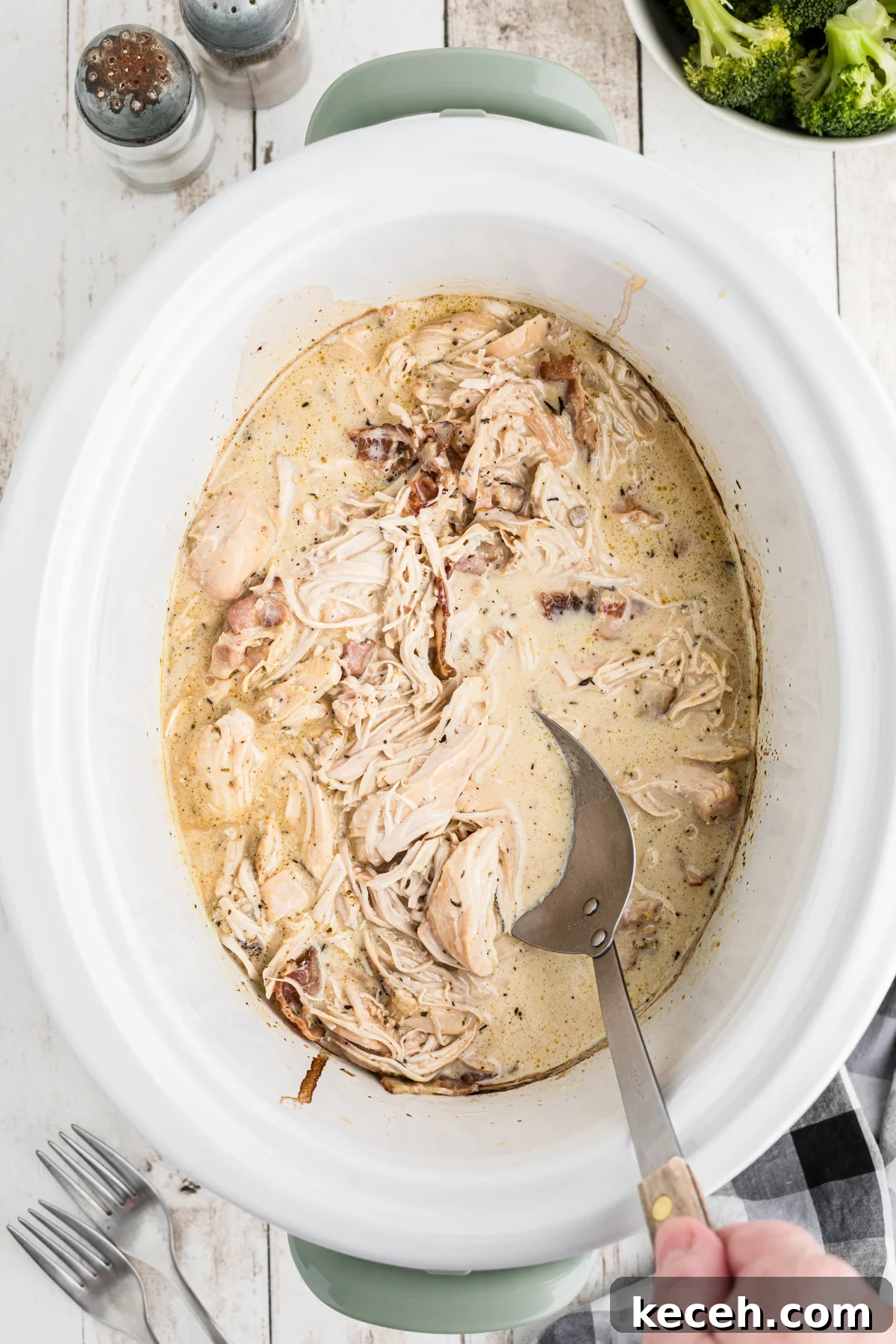 Slow Cooker Chicken in Bacon Gravy — Comforting One-Pot Meal 2 chicken with gravy with bacon with spoon in it.